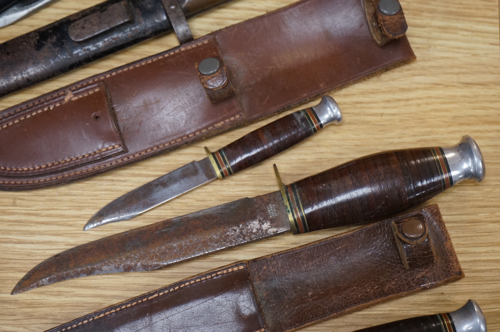 A 1907 bayonet by Wilkinson in its steel mounted leather scabbard, another similar with leather frog, two small British bayonets, a Continental bayonet, and two assorted hunting knives (7)